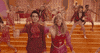 Video gif. Musicians Taylor swift and Brandon dance in colorful mod clothing in the "Me!" music video.