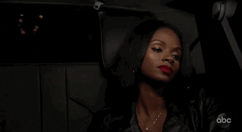 Reality TV gif. Natasha Parker from The Bachelor sits in the backseat of a car on a night drive, looking tired and disappointed as she stares out the window.