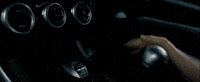 Movie gif. From "The Fast and The Furious," a close-up of a hand shifting gears and then a cut to a shot of a souped-up car passing another car inside of a tunnel, zooming toward us.