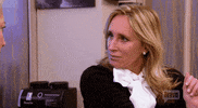 Reality TV gif. Sonja Morgan from Real Housewives of New York looks and two people back and forth in confusion, putting a hand up as she tries to figure out what the point is.