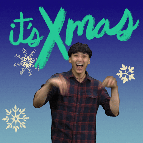 Video gif. Teenage boy laughing and waving limp wrists around wildly with excitement, set against a sky blue background with falling snowflakes. Chalky text above, "It's X-mas."