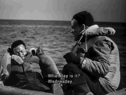 Movie gif. Two men are wearing life vests and sitting in a raft, floating on the sea, in a black and white film. One man asks, "What day is it?" and the other responds with, "Wednesday."