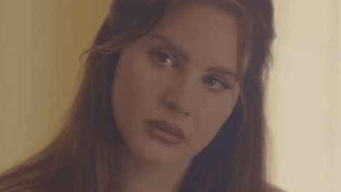 Celebrity gif. A disappointed Lana Del Rey looks sadly at the ground.