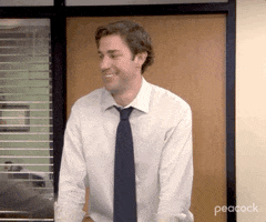 The Office gif. Steve Carell as Michael Scott tackles John Krasinski as Jim Halpert. Jim smiles widely then frowns as he's swept to the ground by Michael.