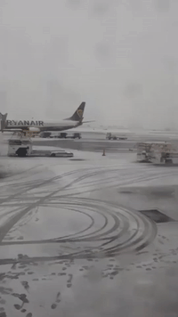 Snow Plows Work on Manchester Airport Runway as Winter Weather Forces Temporary Closure