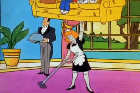 Cartoon gif. Irona in Richie Rich lifts a couch with Richie sitting on it with one hand while vacuuming the living room with the other hand.