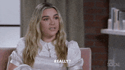 Celebrity gif. Florence Pugh sits in an interview and looks over at the interviewer very seriously, saying, “Really?”