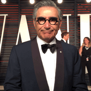 Celebrity gif. Eugene Levy shrugs and raises his hands as if uncertain. 