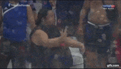 Sports gif. Male soccer fans get riled up out of their seats, taunting someone in a nearby section to fight, putting up fists.