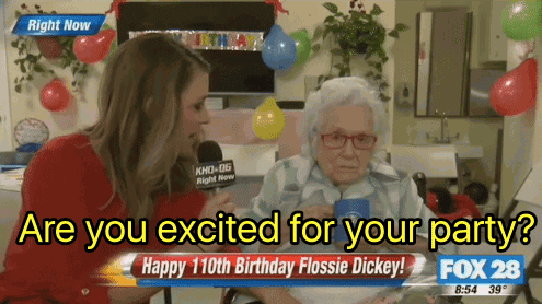 TV gif. A news reporter on Fox turns and tilts a microphone to ask a senior woman a question. She asks, "Are you excited for your party?" The old woman responds, "Not one bit" and the reporter laughs into the microphone. Text on screen reads, "Happy 110th birthday Flossie Dickey!"