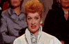 TV gif. Lucille Ball sits in a crowd of people. She pulls her lips back and grimaces in disgust like she wants to look away, but can't. 