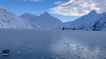 Ice Skaters Glide Over Alaska Glacial Lake