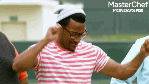 Reality TV gif. MasterChef contestant wearing a beanie and a red-striped shirt does a little victory dance, shrugging his shoulders while waving his arms side to side.