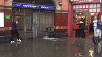 Londoners Cross Flooded Pavement Using Makeshift Chair Bridge
