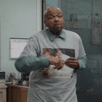 TV gif. William Stanford Davis as Mr. Johnson on Abbott Elementary wearing a t-shirt with Usher on it, dances tauntingly waving a concert ticket in each hand.