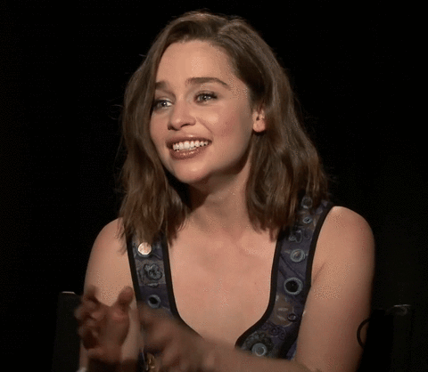 Celebrity gif. Emilia Clarke sits in an interview. She tries to hold in her laughter with a tight smile, but she can't hold it in and bursts out laughing. She can't stop laughing and covers her mouth with her hand. 