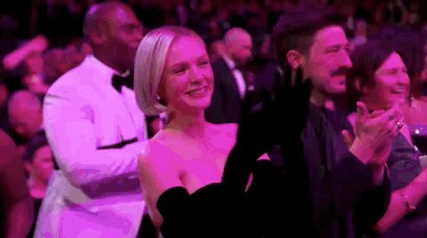 Oscars 2024 GIF. Carey Mulligan, claps happily, taking in the performance.