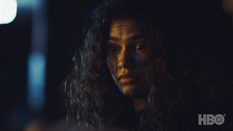 TV gif. Zendaya as Rue on Euphoria looks down at something with wide, nervous eyes. She looks out of the corner of her eye without barely moving her body.