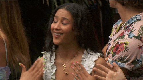 Reality TV gif. Ameerah on Big Brother smiles and fans herself with her hands as she turns toward us.