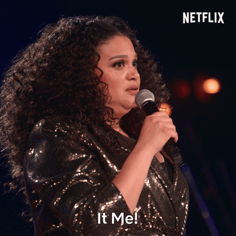 TV gif. Michelle Buteau in the Welcome to Buteaupia comedy special wears a bronze lamé jacket and turns toward us with wide eyes as she says, "It me!"