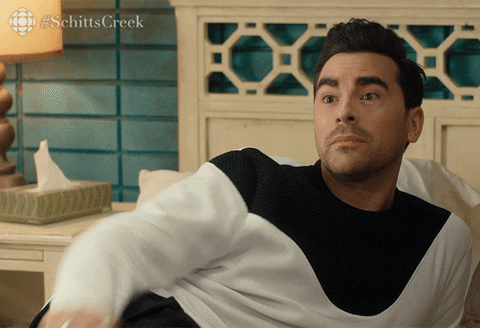 Schitt's Creek gif. Dan Levy as David lays on his side in bed and waves earnestly as he says, "See ya."