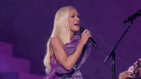 Academy of Country Music Awards gif. Gween Stefani endearingly looks at Blake Shelton who is out of frame. While singing she gently shakes her head and performs with a happy expression on her face.