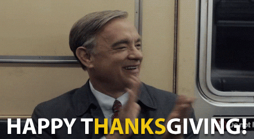 Movie gif. Sitting in a subway seat, Tom Hanks as Mr. Rogers in A Beautiful Day in the Neighborhood smiles and claps his hands. Text, "Happy Thanksgiving!" In the text, "Hanks" is highlighted yellow.