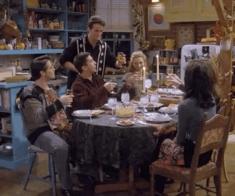 Friends gif. All of the friends gather around a table and raise their glasses towards the center to cheers .