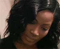 Video gif. Woman looks down at something and gasps widely in shock, lifting her eyebrows up high.