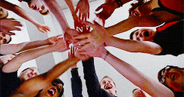 TV gif. Members of the New Directions on Glee hold their hands together as they stand in a circle, and then fly their arms up into the air at the same time.