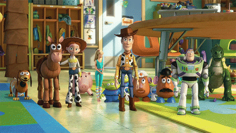 Cartoon gif. The main group of toys in Toys Story 3 stand in a group. We zoom into barbie who looks up shyly and gasps as she looks up at Ken’s shocked and enthralled expression.