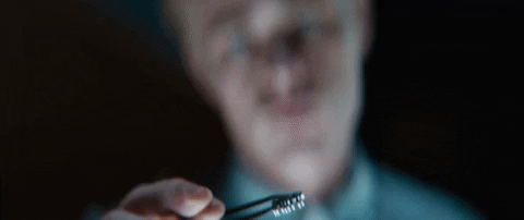 TechDogs-"Introduction"-"Scientist Examining a Microchip: A close-up of a scientist carefully holding a microchip with tweezers, inspecting its intricate details under a focused light."