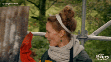 TV gif. We pull out quickly from a woman on The Great Pottery Throwdown. She leans into a high five another woman who we see move into frame. 