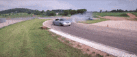 Video gif. A silver lowrider sedan drifts around a curb, kicking up a cloud of dust.
