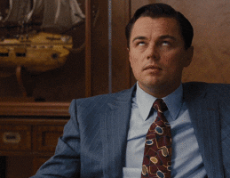 Movie gif. Leonardo Dicaprio as Jordan Belfort in Wolf of Wall Street rolls his eyes while muttering something and then leans over to bite his fist in frustration. 