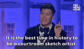 Video gif. Saturday Night Live's Colin Jost stands at a podium at the 2024 White House Correspondents' Dinner and delivers a joke. He points up with his right hand as he says "It is the best time in history to be a courtroom sketch artist."