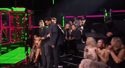 Celebrity gif. While the crowd stands in applause, singe The Weekend, steps on the stage of the MTV European Music Awards.