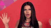 Music video gif. From the video for "Ur Cool," Saara sings and winks at us, holding her hand out to the side and flipping it from front to back.