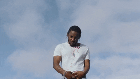 Music video gif. Kendrick Lamar in his video for Element looks down toward us as he clasps his belt buckle and sways slowly to the side. Text, "Damn."