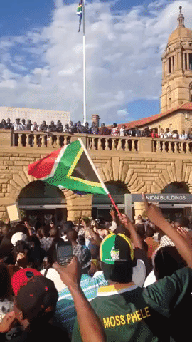 People celebrate the life of Nelson Mandela outside Pretoria Union Buildings