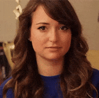Video gif. A woman tries to wink at us but fails but tries again and again and never succeeds fully succeeds. 