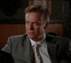Celebrity gif. Christopher McDonald looking serious in a business suit and then cracking up with absurdity.