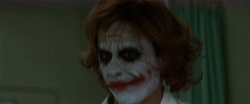 Movie gif. Dressed as a nurse in full Joker makeup, Heath Ledger as The Joker in The Dark Knight smiles creepily and says, “hi.”