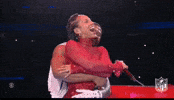 Celebrity gif. Alicia Keys and Usher embrace on stage at the Super Bowl halftime show. Usher gives Alicia a back hug and she closes her eyes and laughs with her mouth open.