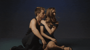 TV gif. Chad Duell as Michael and Chloe Lanier as Nelle on General Hospital sit wantonly side by side. He leans towards her as she looks seductively ahead. 