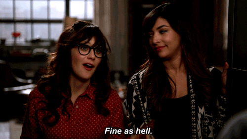 TV gif. Zooey Deschanel as Jess Day in New Girl waves her finger and sways while saying “Fine as hell,” as Hannah Simone as Cece Parekh looks at Deschanel then turns forward and bites her lower lip.
