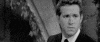 Celebrity gif. Ryan Reynolds is in black and white and he looks very distressed but suddenly turns towards the camera and gives us a cheeky stare down and smile.