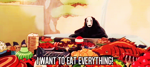 Anime gif. No Face from the movie Spirited Away flings his arms up in the air as he sits behind an overwhelming array of food. He proclaims, "I want to eat everything!"