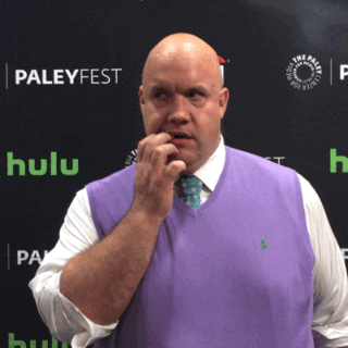 Celebrity gif. Guy Branum mimes biting his nails, nervously glancing back-and-forth.