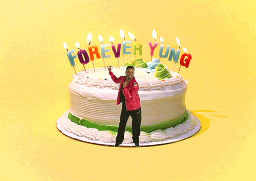 Video gif. Alfonso Ribeiro does the Carlton dance, swinging his arms around and moving his legs in and out, in front of a huge cake that has candles that spell out, “Forever yung.”